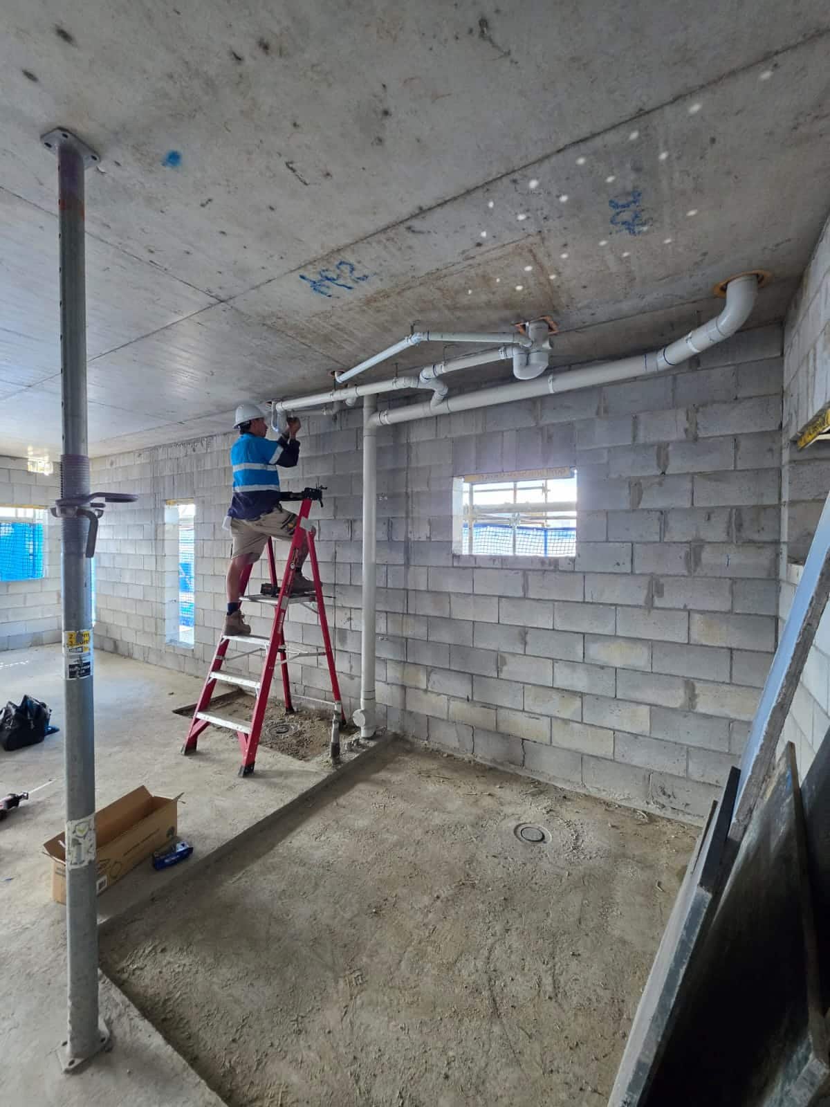 Commercial plumber installing drainage pipework on a construction site in Hervey Bay